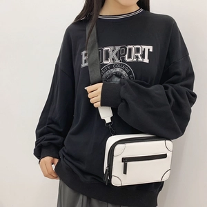 White box-style crossbody bag with black zipper detail and wide adjustable strap