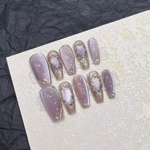 Detail of lavender cat-eye handmade press-on nails with gold lines and rhinestones