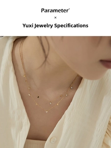 Close-up of layered gold titanium steel necklace with zircon and geometric charms