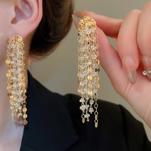 Detail of 18k gold plated tassel earrings with sparkling crystals and metal sequins
