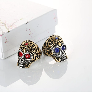 Vintage skull ring for men in silver and gold steel with red and blue gemstone eyes
