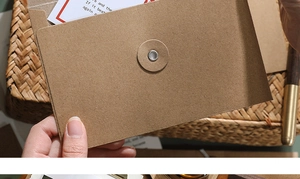 Close-up of brown kraft paper envelope with vintage string and button tie closure