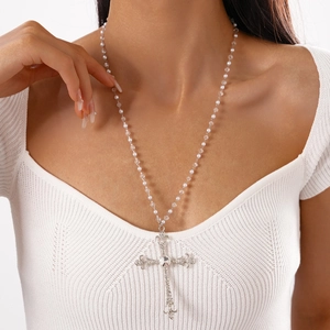 Close-up of pearl beaded cross pendant necklace with rhinestones worn by a model
