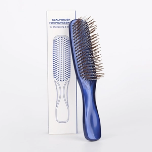 Close-up of blue scalp massage brush with professional white and blue packaging box