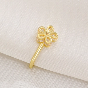 Close-up of golden five-petal flower nose clip with clear zircon on white silk