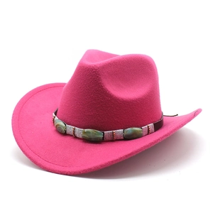 Détail d'un chapeau de cowboy rose avec pierre turquoise et sangle en cuir brun