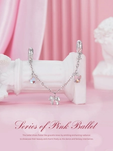 Detail of s925 silver safety chain with pink ballet bow and heart charms on roman column