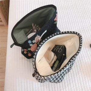 Detail of floral embroidery and houndstooth makeup bags with durable zipper and fabric lining