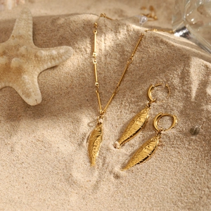 18K gold stainless steel koi fish pendant necklace and earrings set on beach sand