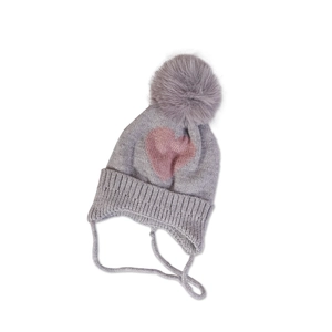 Close-up of grey knit baby hat with ear flaps, pink hearts and faux fur pom-pom