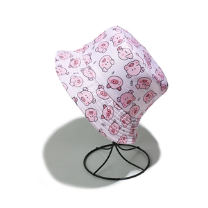 Close-up of pink bucket hat featuring cute cartoon pig patterns and premium cotton texture