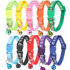Detail of colorful pet collars with paw prints, metal bells, and adjustable buckles
