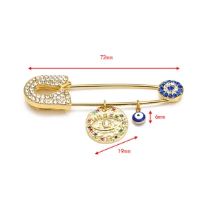 Detail of gold Evil Eye brooch with dimensions showing 72mm length and rhinestones