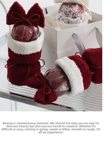 Close-up of plush Christmas gift bags with red bows and apple packaging material