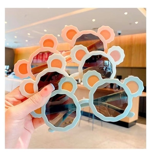 Close-up of cute children's bear ear sunglasses in pastel colors like pink and mint