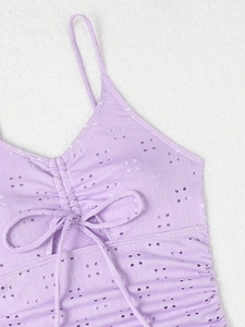 Detailed macro view of lavender eyelet embroidered fabric with ruched front and bow detail