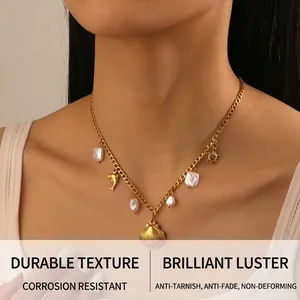 Detail of a gold stainless steel necklace featuring baroque pearls and shell charms