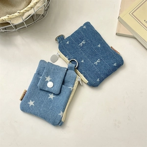 Detail of denim card holders in light and dark blue with white star patterns and button closure
