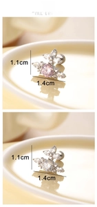 Macro detail of cross-shaped flower stud earrings featuring pink and clear cubic zirconia
