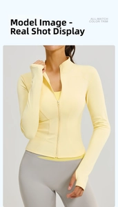 Detail of light yellow yoga jacket with stand collar, zipper, and thumb holes on sleeves