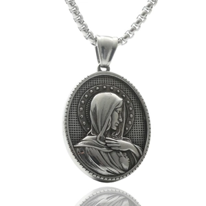 Macro shot of silver stainless steel pendant featuring Virgin Mary relief with starry border