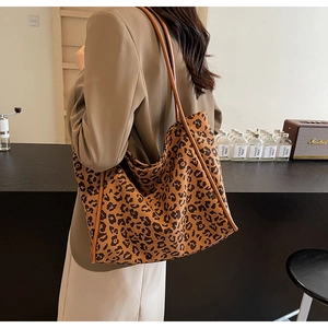 Close-up of leopard print canvas tote bag on female model in a cozy cafe setting