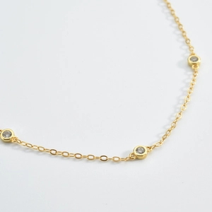 Detailed close-up of a gold S925 sterling silver bracelet with sparkling bezel-set diamonds
