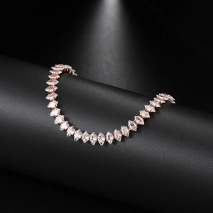 Macro detail of rose gold tennis bracelet featuring marquise-cut cubic zirconia crystals