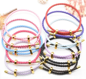 Flat lay of colorful braided leather cord bracelets with gold adjustable buckles