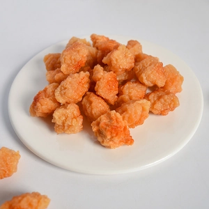 Dettaglio ravvicinato di ciondoli realistici a forma di nugget di pollo su un piatto bianco