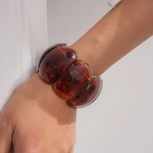 Close-up of amber marbled acrylic resin chunky stretch bangle on wrist