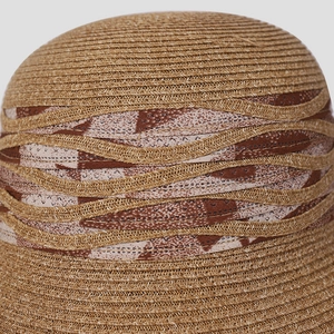 Détail du tissage en paille serré et du ruban à motifs géométriques sur le chapeau
