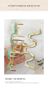 Detailed shot of large golden snake hair claw with green marble acetate pattern