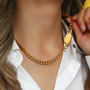 Close-up of chunky gold stainless steel oval link chain necklace worn by a fashion model