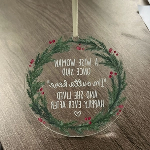 Detail of round acrylic ornament with berry wreath and humorous engraved quote