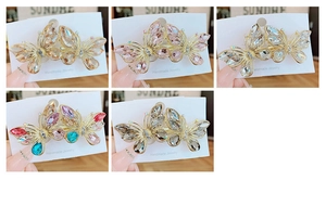 Detail of five handmade butterfly hair clips with colorful crystals and wire borders
