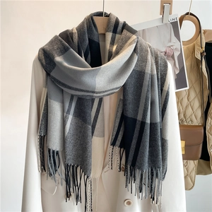 Sciarpa classica a quadri nero grigio e bianco con frange su blazer bianco