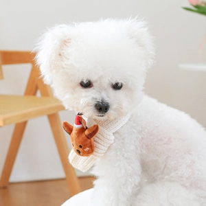 Close-up of white knitted pet scarf with a brown elk mascot on a Bichon Frise dog
