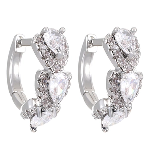 Detailed close-up of silver huggie earrings with pear-cut cubic zirconia and pavé stones