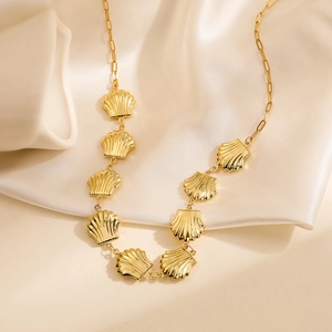 Elegant 18K gold-plated stainless steel necklace with shell pendants on silk background