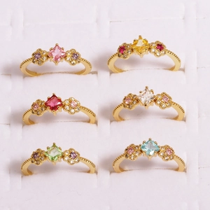 Macro shot of colorful gemstone flower rings with square zircon and gold milgrain finish