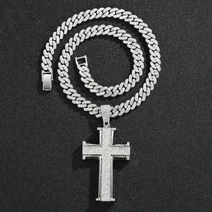 Vue détaillée du pendentif croix argenté serti et fermoir de la chaîne cubaine