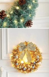 Detail of Christmas wreath with warm LED lights, pine cones and festive golden bows