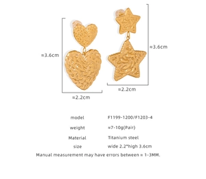 Vue détaillée des boucles d'oreilles en acier titane doré avec pendentifs étoile et cœur