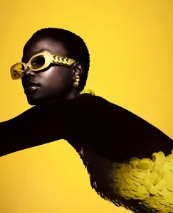 Detail of yellow fashion sunglasses featuring oversized frames and metal chain temples