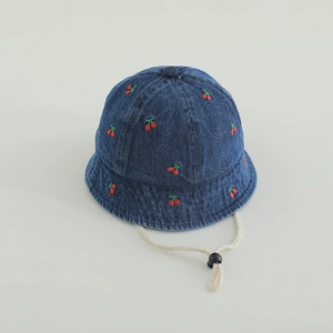Detail of baby denim bucket hat with red cherry embroidery and white windproof strap