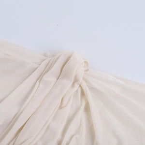 Close-up of beige sheer mesh fabric showing detailed texture and lightweight drape