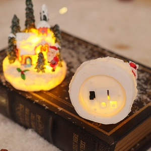Detail view of glowing Christmas resin house featuring Santa and LED switch base