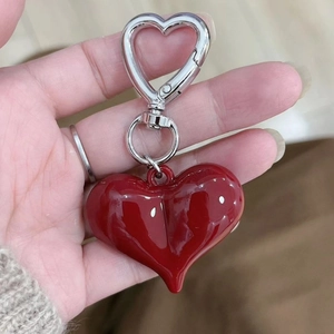 Close-up of a glossy red 3D heart-shaped pendant with a silver metal spring clasp