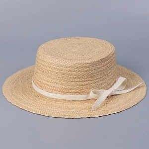 Detailed macro view of a natural straw boater hat featuring an elegant white bow.